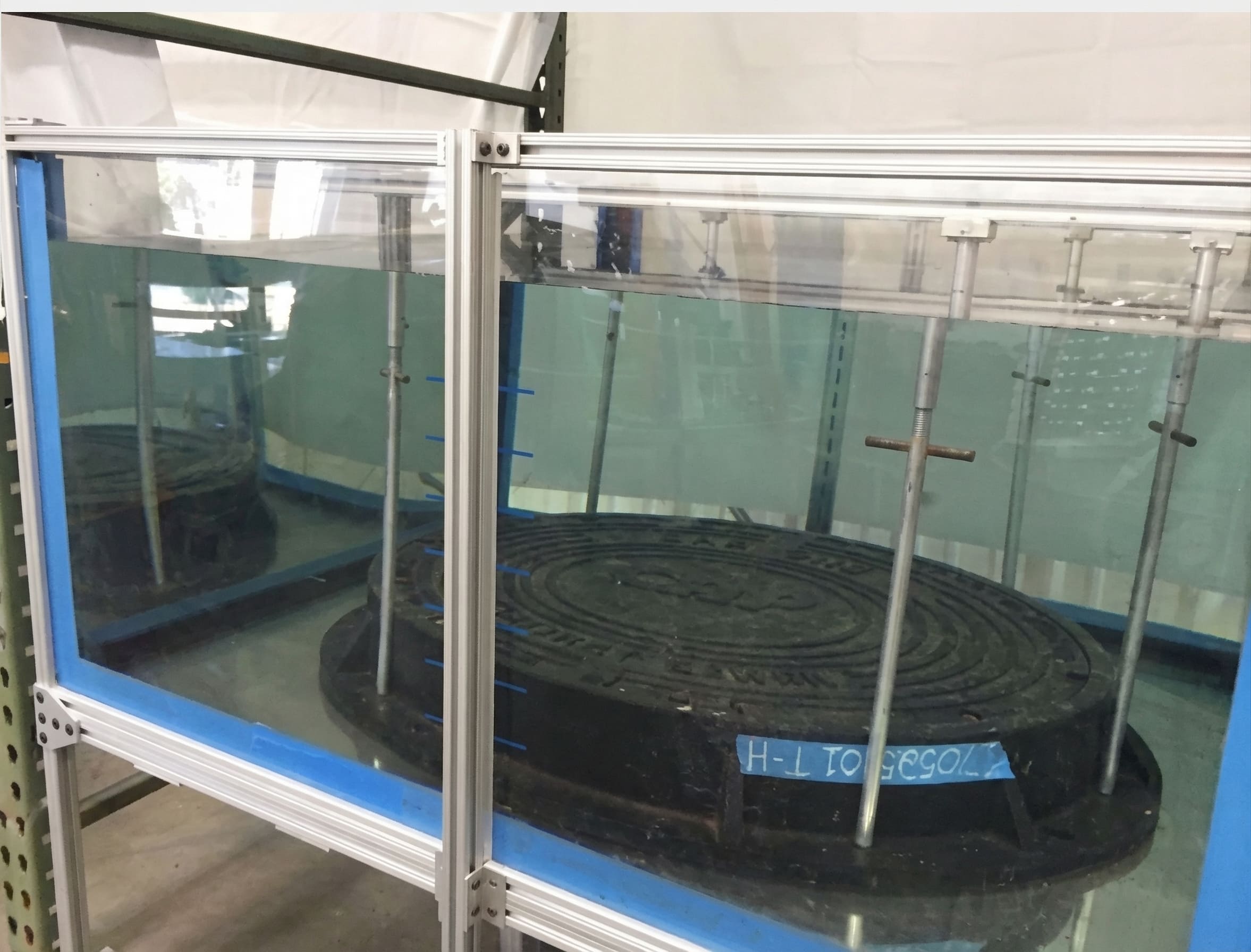 A sizable circular metal tank featuring a reflective exterior and an empty center. composite manhole cover